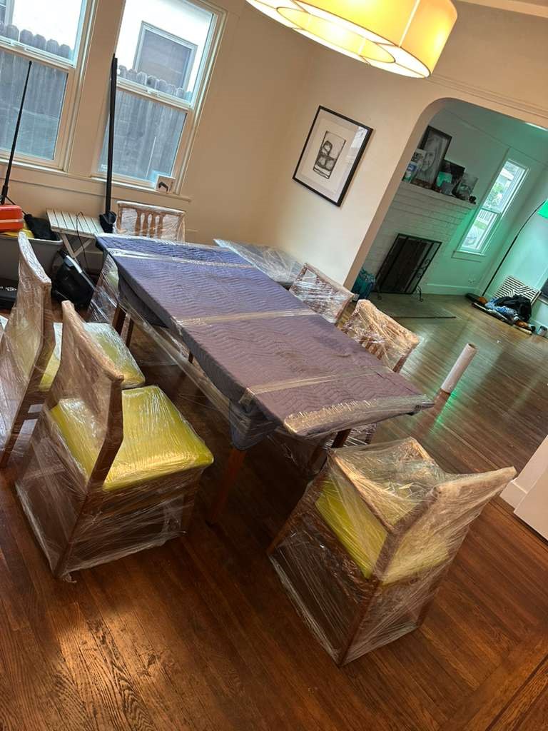 Wrapped dining table and chairs prepared for moving