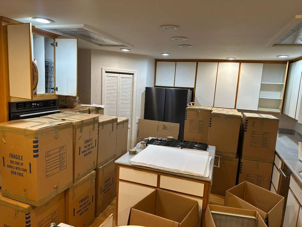 Kitchen packed with dish boxes and moving supplies